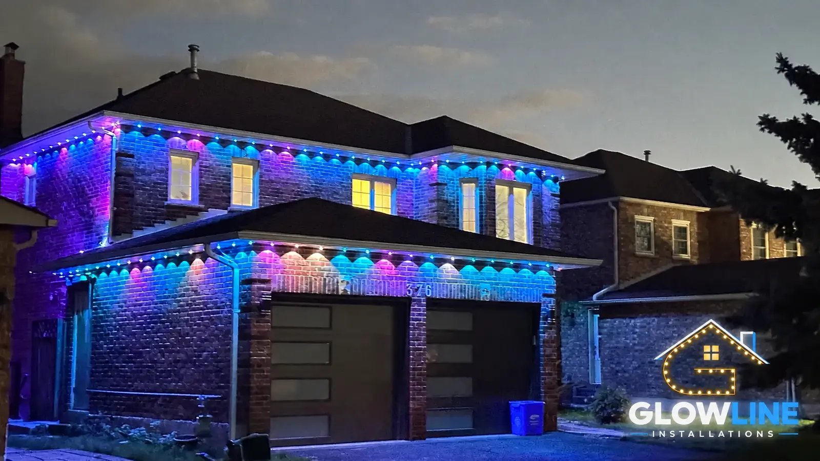 Two-storey home with blue permanent outdoor roofline lighting